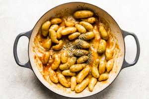 shallots, potatoes, and rosemary tossed with honey mustard sauce being cooked in a braiser