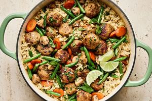 One Pot Chicken Meatball and Green Curry Rice in skillet with green beans and carrots topped with fresh basil and lime juice