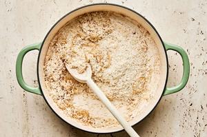 rice, shallots and garlic being stirred in a skillet