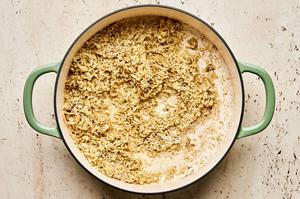 green curry paste, rice, shallots and garlic being stirred in a skillet