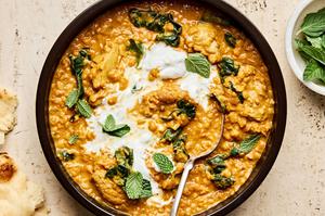 a bowl of one pot chicken and lentils featuring tender chicken simmered with lentils & aromatic herbs topped with fresh mint