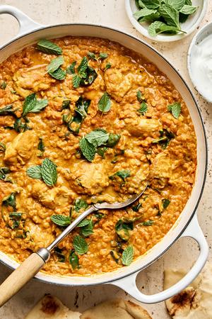 a pot of one pot chicken and lentils featuring tender chicken simmered with lentils & aromatic herbs topped with fresh mint