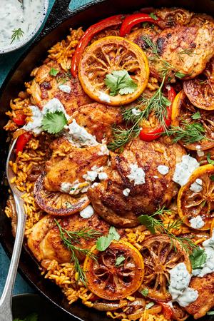 one pot chicken and rice in a skillet topped with homemade herb yogurt