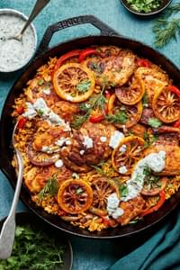 one pot chicken and rice made with chicken thighs, shallots, bell peppers, spices and jasmine rice topped with herb yogurt