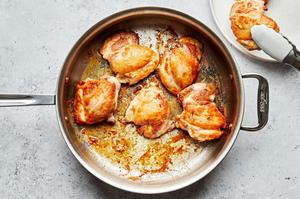 skinless chicken thighs seasoned with salt being browned in olive oil in a large pan