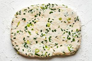 onion chive biscuit dough rolled out on the counter