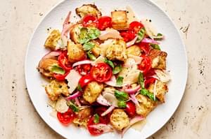 a bowl of Panzanella made with toasted bread, basil, tomatoes, parmesan and homemade dressing