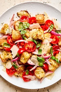 a bowl of Panzanella made with toasted bread, basil, tomatoes, parmesan and homemade dressing