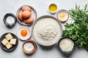 flour, eggs, salt, olive oil, butter, parmesan, garlic, tarragon and parsley in prep bowls
