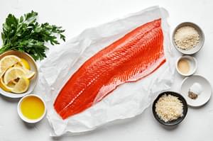 1 pound salmon filet, garlic powder, salt, pepper, butter, breadcrumbs, parmesan, parsley and lemon wedges in prep bowls