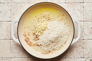 chicken stock, butter, shallots, garlic and arborio rice being cooked together in a pot for parmesan risotto