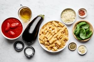 Italian pasta ingredients: Prep bowls with San Marzano tomatoes, EVOO, herbs, eggplant for authentic Pasta alla Norma recipe