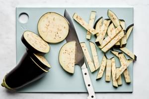 Fresh Italian eggplant preparation: Slicing aubergine for traditional Sicilian Pasta alla Norma recipe, cooking steps