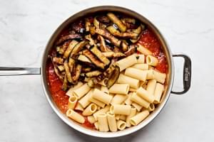 Combining Pasta alla Norma: Fresh eggplant and al dente pasta tossed in authentic Italian tomato sauce