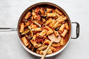 Traditional Pasta alla Norma cooking in a sauce pan: Sicilian eggplant pasta dish with homemade marinara and fresh herbs