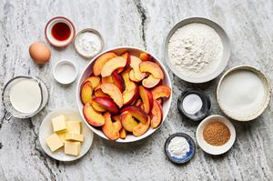 peaches, sugar, cornstarch, vanilla, almond extract, flour, salt, butter, cream & eggs in prep bowls to make peach cobbler