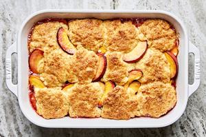 baked peach cobbler made with sugar, vanilla, almond extract and homemade biscuits