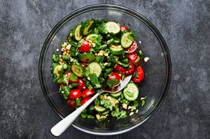 green beans, tomatoes, cucumbers, peanuts, cilantro, lime juice, fish sauce, soy sauce & garlic being tossed in a bowl