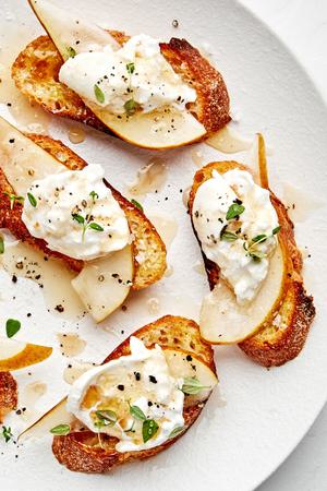 Pear and Burrata Crostini drizzled with sherry vinegar and honey and sprinkled with thyme, salt and pepper