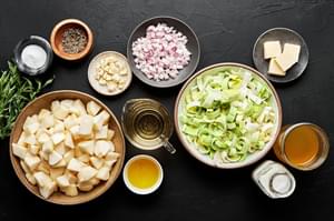 diced pears, shallots, leeks, heavy cream, butter, stock, olive oil, garlic and tarragon in bowls for pear bisque