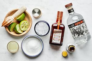 tequila, orange liqueur, lime juice, angostura bitters, salt and lime wedges in prep bowls to make the perfect margarita