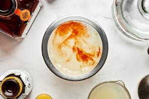 tequila, orange liqueur, lime juice and angostura bitters being added to a cocktail shaker
