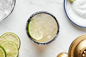 a margarita made with tequila, orange liqueur, lime juice and angostura bitters served with a salt rim and a lime wedge