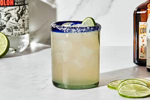 a margarita made with tequila, orange liqueur, lime juice and angostura bitters served with a salt rim and a lime wedge