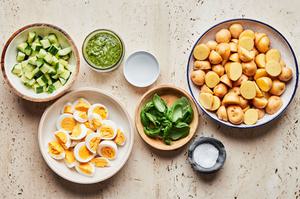 Yukon gold potatoes, sliced hard boiled eggs, cucumber, basil, salt, white vinegar and pesto in prep bowls