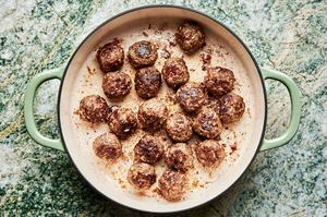 homemade porcupine meatballs being cooked in olive oil in a skillet