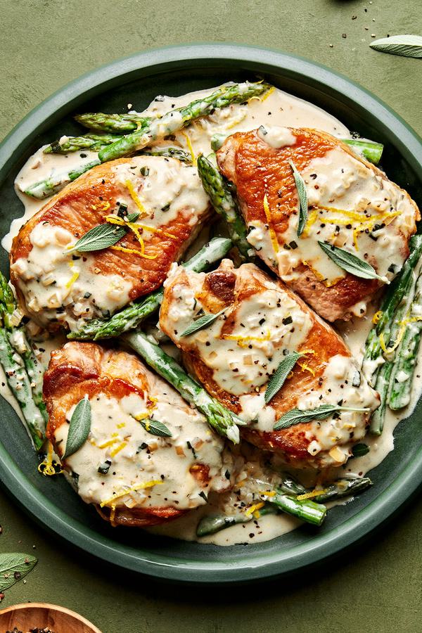 4 Pork Chops with Asparagus and a Lemon Sage Cream Sauce on a serving plate
