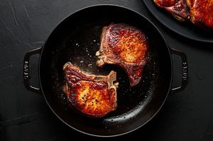2 bone in pork chops seasoned with salt and pepper browned in olive oil in a skillet
