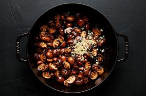 mushrooms and garlic being cooked in butter in a skillet