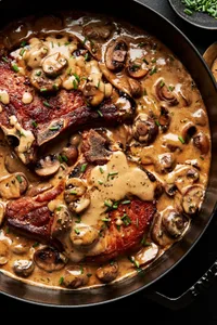 pork chops with mushroom cream sauce in a skillet