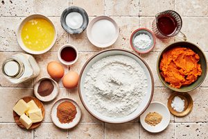milk, pumpkin puree, eggs, butter, vanilla, flour, baking powder & soda, sugar, spices and syrup in prep bowls on the counter