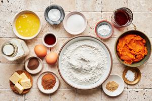 milk, pumpkin puree, eggs, butter, vanilla, flour, baking powder & soda, sugar, spices and syrup in prep bowls on the counter