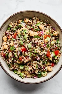 Homemade quinoa salad made with basil, garlic, chickpeas, red onion, cucumber, tomato, bell pepper, jalapeño and parsley