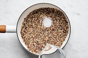 quinoa, water and salt being added to a pot