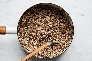 a pot of cooked quiona being stirred with a spoon