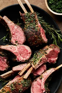 rack of lamb, sliced and topped with mint sauce on a serving platter