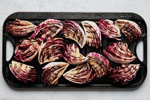 radicchio wedges brushed with olive oil and seasoned with salt being cooked on a grilled pan