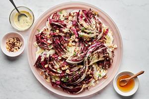 Radicchio salad with Creme Fraiche Vinaigrette sprinkled with toasted hazelnuts, thyme and drizzled with honey on a plate