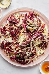 Radicchio salad with Creme Fraiche Vinaigrette sprinkled with toasted hazelnuts, thyme and drizzled with honey on a plate