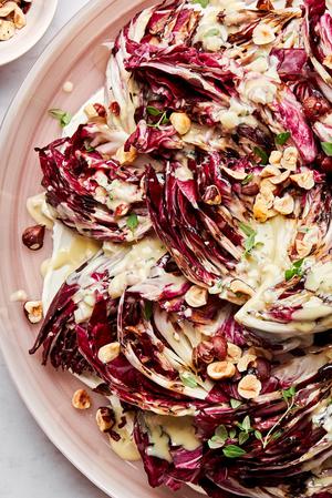 Radicchio salad with Creme Fraiche Vinaigrette sprinkled with toasted hazelnuts, thyme and drizzled with honey on a plate