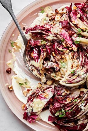 Radicchio salad with Creme Fraiche Vinaigrette sprinkled with toasted hazelnuts, thyme and drizzled with honey on a plate