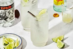 2 glasses of ranch water made with tequila, lime juice and sparkling mineral water garnished with a lime wedge