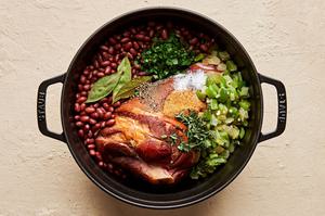 ingredients for homemade red beans rice in a pot made with andouille and hot louisiana sausage, ham hock, peppers & onions