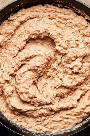 homemade refried beans made with onion, salt, lard, garlic and taco seasoning