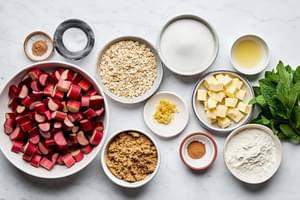 rhubarb, butter, flour, oats, brown sugar, sugar, nutmeg, cinnamon, salt, and mint in prep bowls to make rhubarb crisp