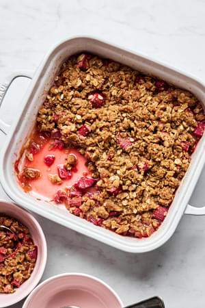 homemade rhubarb crisp being spooned into serving bowls